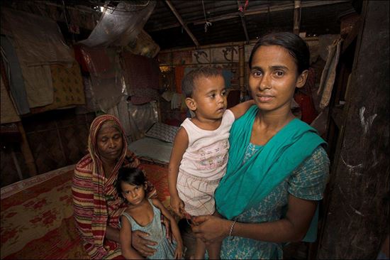Junge Frau mit Kind auf dem Arm. Eine ältere Frau mit Kind im Arm stehen daneben. Junge Frau mit Kind auf dem Arm. Eine ältere Frau mit Kind im Arm stehen daneben.