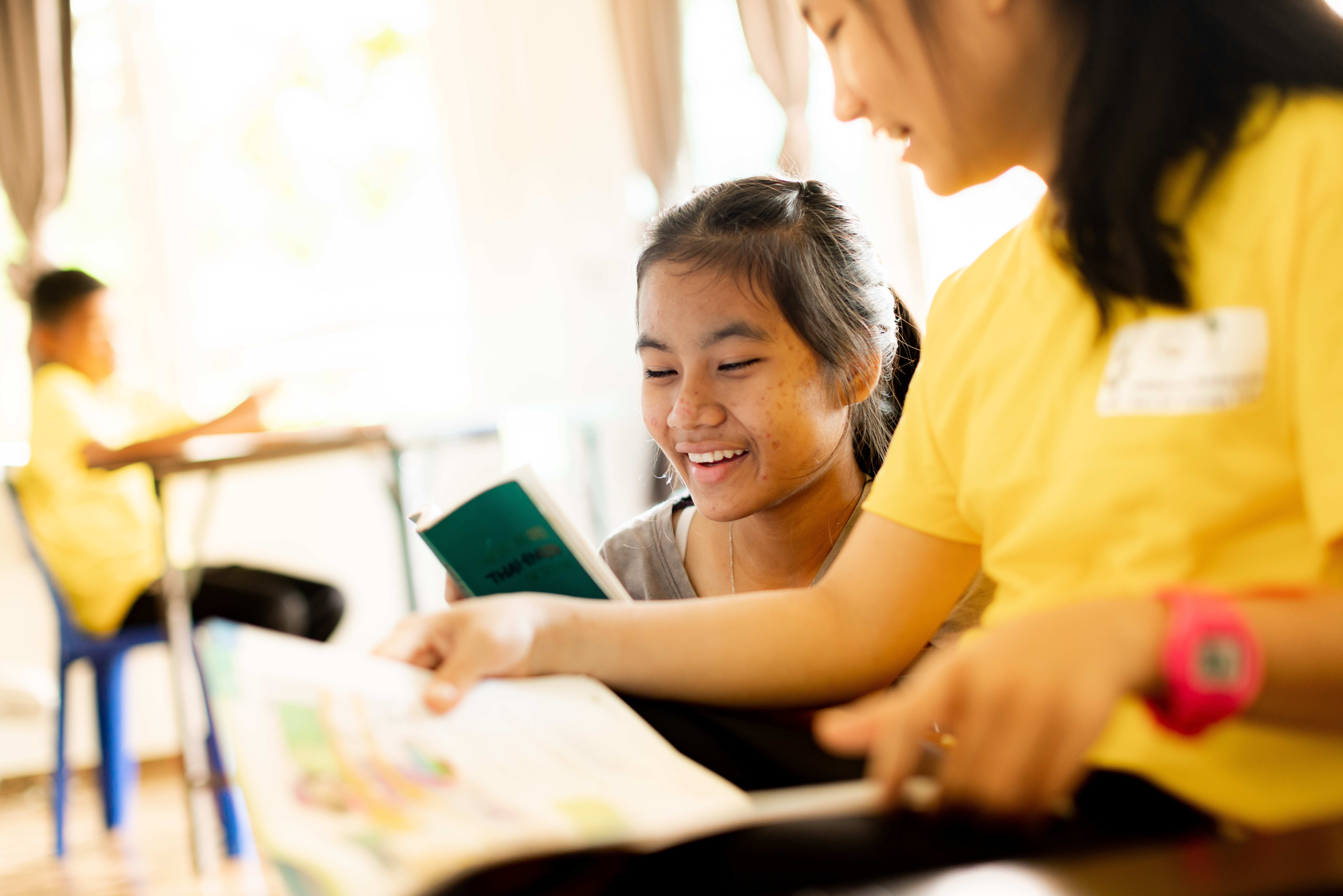Thailändische Mädchen lesen und lachen. (Quelle: Jakob Studnar)