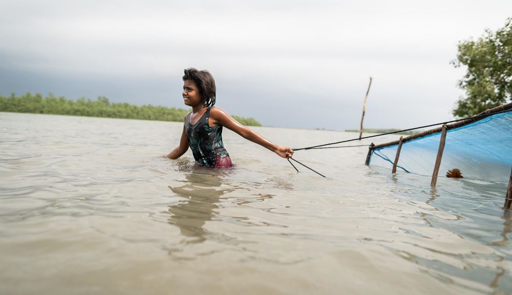 Ein junges Mädchen fischt nach Shrimp in Bangladesch (Quelle: Kindernothilfe) Ein junges Mädchen fischt nach Shrimp in Bangladesch (Quelle: Kindernothilfe)