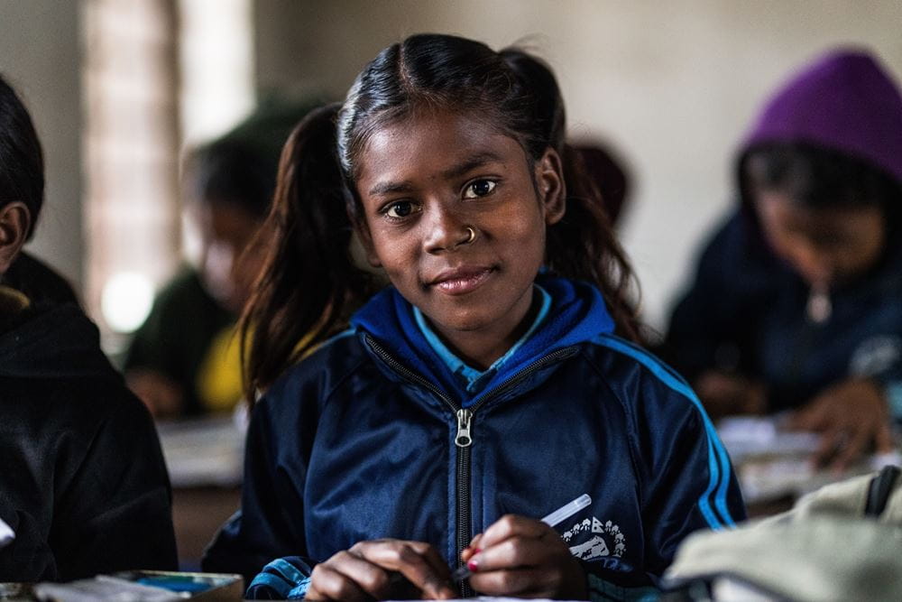 Gamya, ein Mädchen aus Nepal, ist froh, dass sie nicht mehr arbeiten muss. Die Schule macht ihr viel Freude. Auf dem Bild sitzt sie im Klassenraum und schaut in die Kamera. (Foto: Martin Bondzio) Gamya, ein Mädchen aus Nepal, ist froh, dass sie nicht mehr arbeiten muss. Die Schule macht ihr viel Freude. Auf dem Bild sitzt sie im Klassenraum und schaut in die Kamera. (Foto: Martin Bondzio)