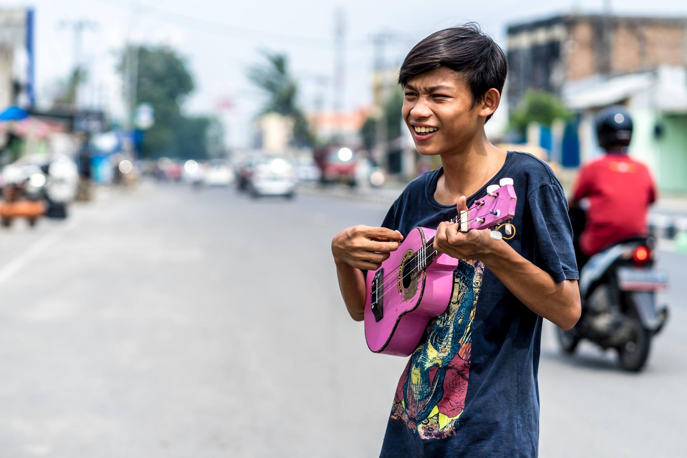 Ein Junge spielt Gitarre auf der Straße, um Geld zu verdienen (Quelle: Lennart Zech/KNH)