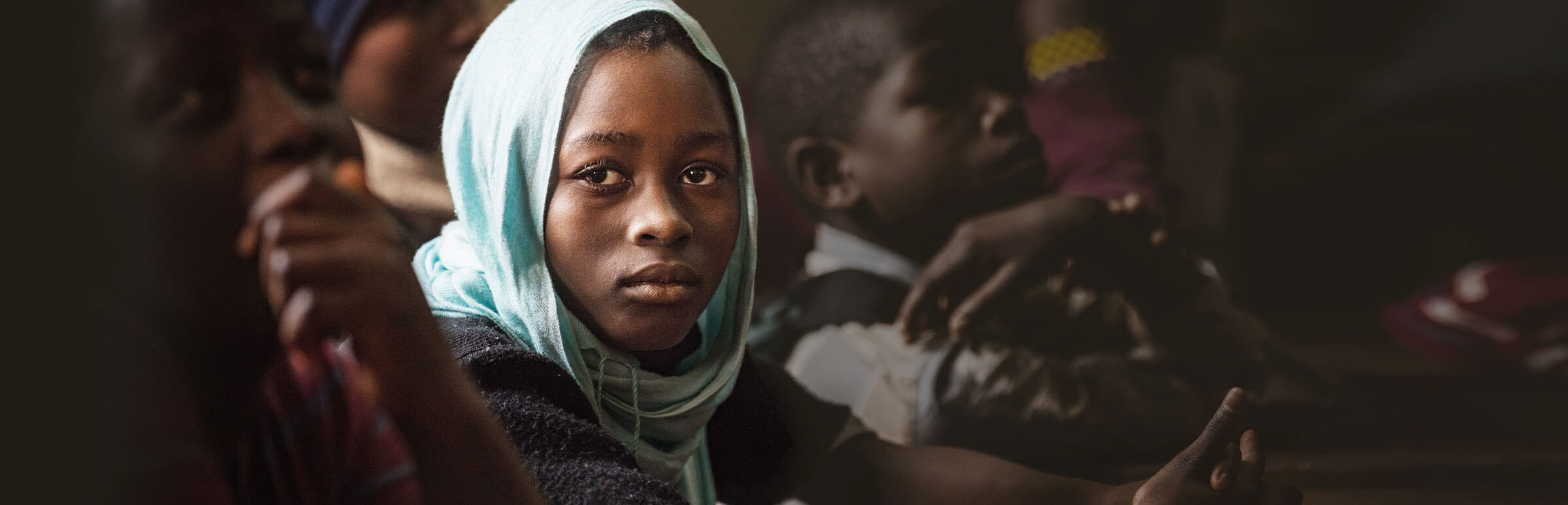 Ein afrikanisches Mädchen mit Kopftuch schaut nachdenklich in die Kamera. (Quelle: Lars Heidrich)